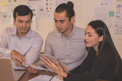 Colleagues analyzing data on desk at office