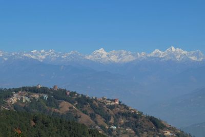 Scenic view of snowcapped mountains against clear blue sky