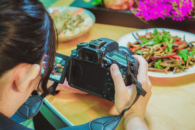 Midsection of woman photographing with mobile phone