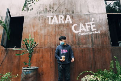 Man standing by text on wall