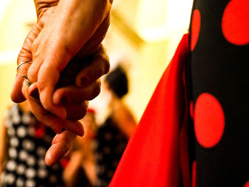 Close-up of hand holding red leaf