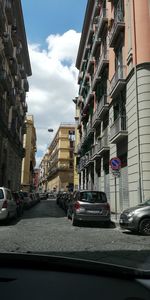 View of city street and buildings against sky