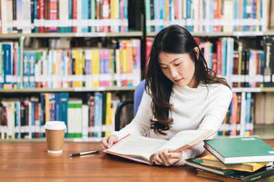 Young woman sitting on book