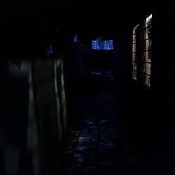 Empty walkway along buildings at night