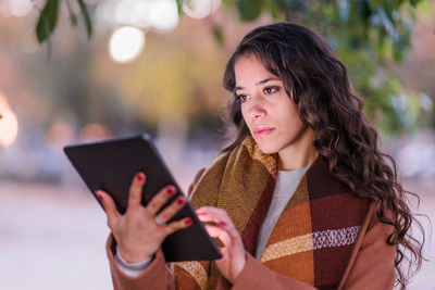 Young woman using digital tablet outdoors