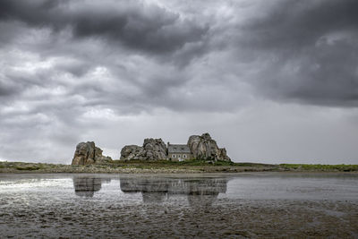 Built structure by sea against sky