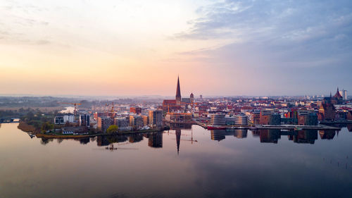 High angle view of buildings against cloudy sky during sunset