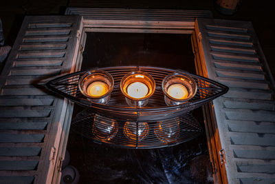 Low angle view of illuminated tea lightshow on a mirror 