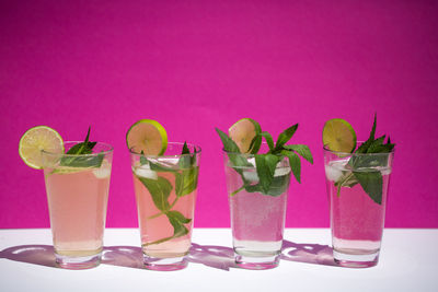 Close-up of drink in glasses against pink background