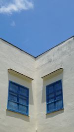 Low angle view  to blue shuttered building against blue sky