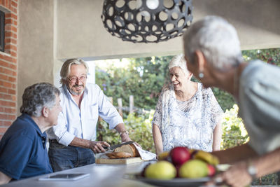 Two happy senior couples together on terrace