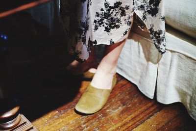 Low section of woman standing on hardwood floor