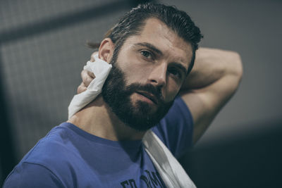 Beautiful man wipes the sweat after a training session. young sporty boy at the end of the match. 