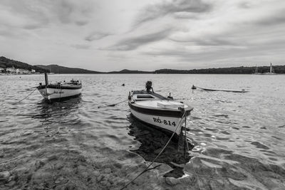 Boats moored in sea against sky