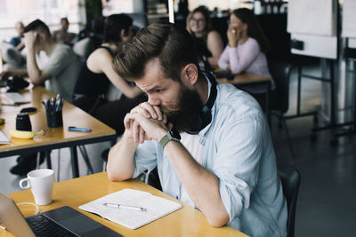 Worried businessman working on laptop at desk in workplace