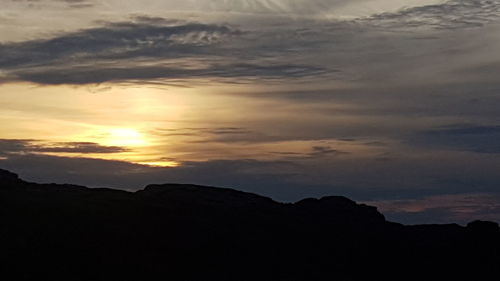 Low angle view of silhouette mountain against dramatic sky