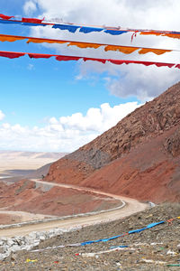 Scenic view of road leading towards mountains against sky
