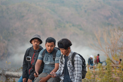 Portrait of men standing against landscape