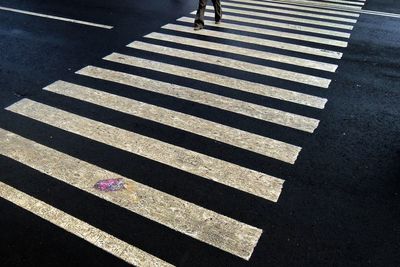 Low section of man walking on zebra crossing