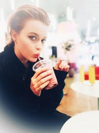 Portrait of young woman drinking coffee