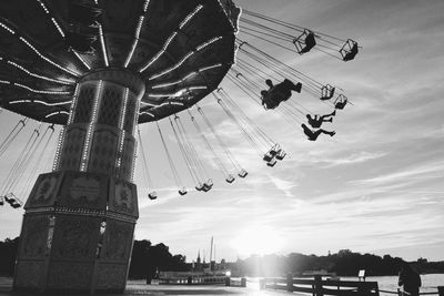 Low angle view of chain swing ride against sky