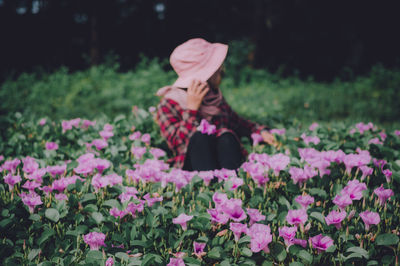 Woman with pink flowers in field