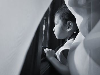 Portrait of boy looking through window