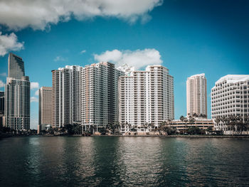 Modern buildings by city against sky