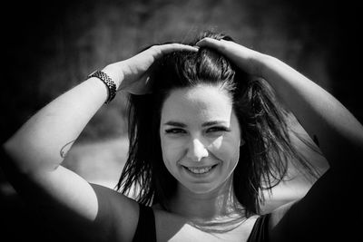 Portrait of smiling young woman with arms raised