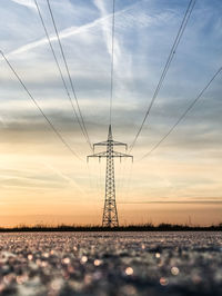 Low angle view of electricity pylon against sky