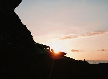 Silhouette rock formations against sky during sunset