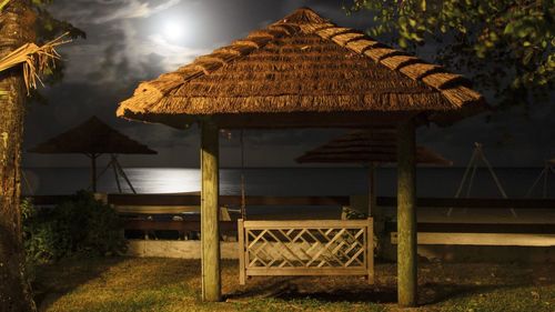 Swing in gazebo by sea at night