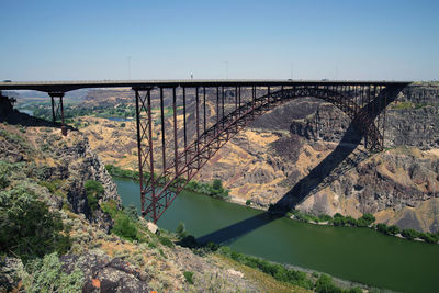 Arch bridge over river against sky