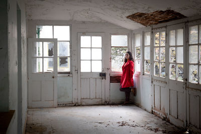 Woman standing in corridor of abandoned building