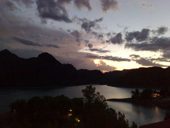 Scenic view of lake and mountains against sky at sunset