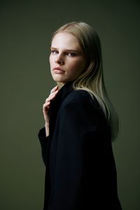 Young woman standing against gray background