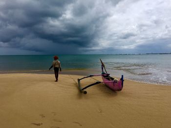 Man standing on beach against sky