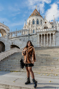 Young woman standing on steps of the halaszbastya or fisherman's bastion in budapest, hungary