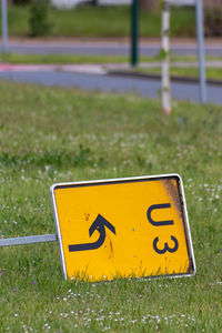 Close-up of yellow sign on field