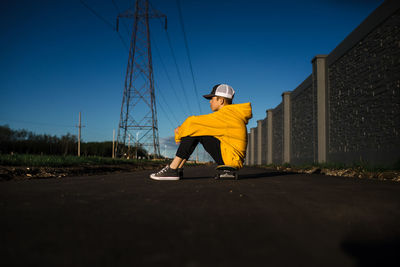 Teen boy sitting on skateboard in the city