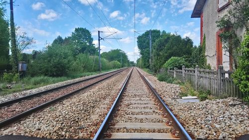 Railroad tracks amidst trees against sky