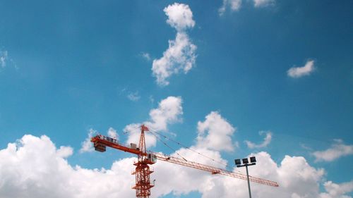 Low angle view of crane against blue sky