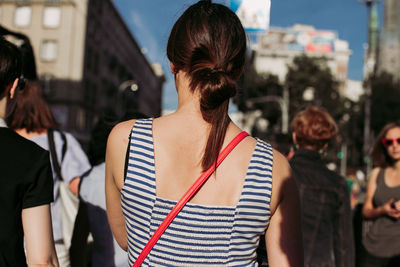 Rear view of woman standing on street in city