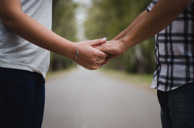 Midsection of couple holding hands