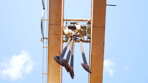 Low angle view of chain hanging on pole against sky