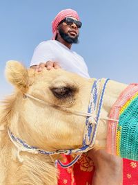 Portrait of woman with camel against clear sky