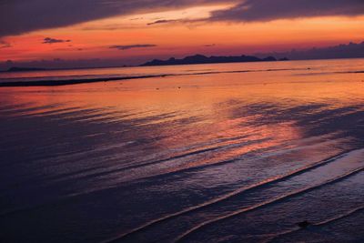 Scenic view of sea against dramatic sky during sunset