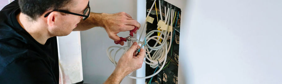 Technician cutting cable to install telecommunication box