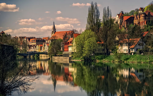 Scenic view of lake by buildings against sky