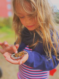 Close-up of cute girl holding butterfly